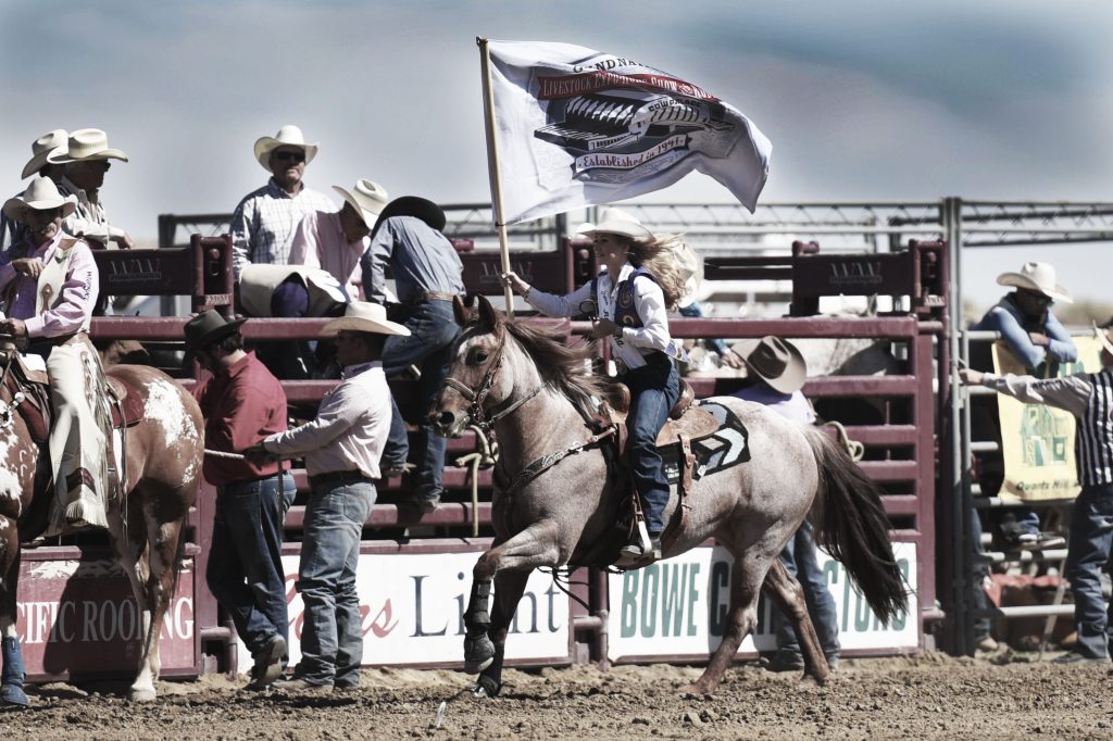 Lady in Waiting - Miss Rodeo California 2017, proudly displaying the flag of the Grand National Rodeo at the 2016 RAM PRCA California Circuit Finals Rodeo